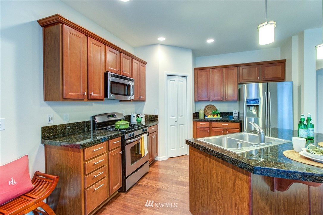 3110 183rd Place Southeast Bothell, WA 98012 - Photo 22 of 40 a kitchen with stainless steel appliances granite countertop a stove a sink and a microwave