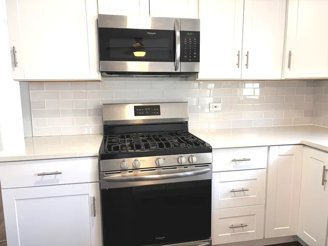 a stove top oven sitting inside of a kitchen