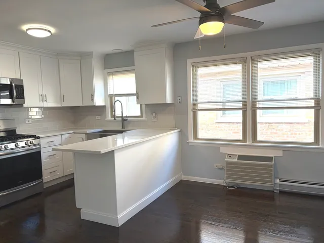 a kitchen with granite countertop a stove a sink and a window