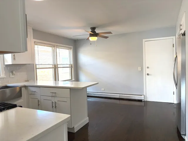 a kitchen with a window a ceiling fan and a refrigerator