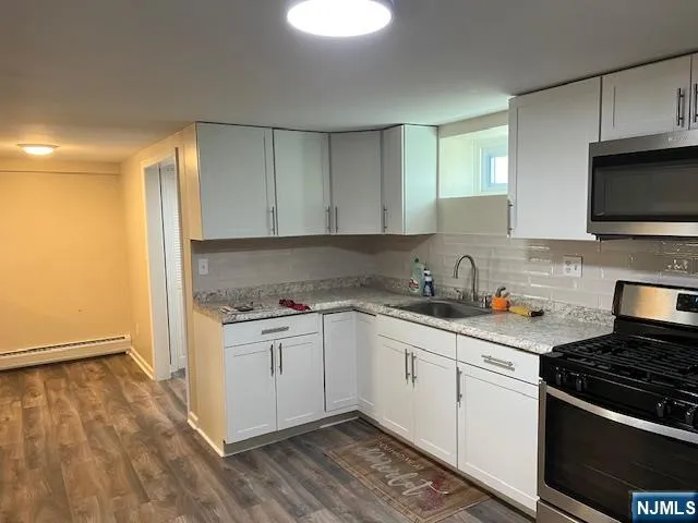 a kitchen with a refrigerator stove and white cabinets