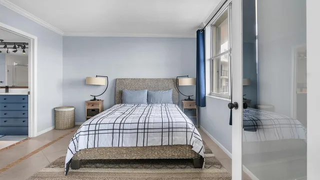 a bedroom with a bed a lamp and window