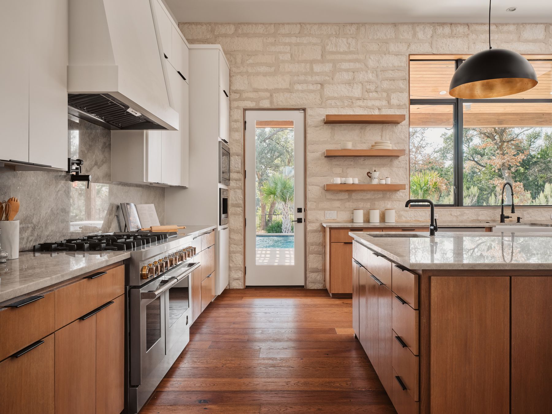 183 Tiffanie Way Austin, TX 78737 - Photo 11 of 37 Kitchen featuring light stone countertops, double oven range, decorative light fixtures, open shelves, and dark wood-style flooring