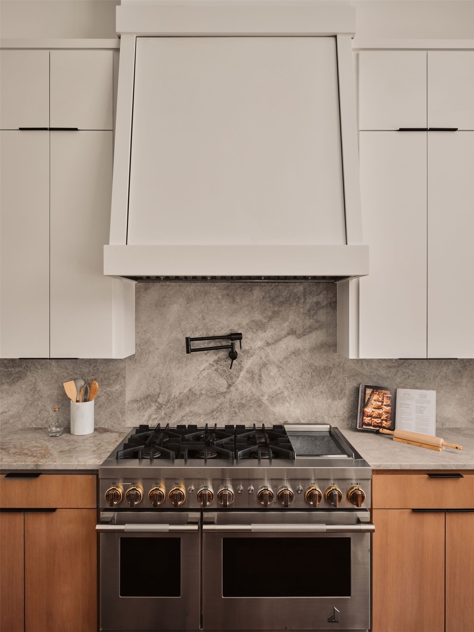 183 Tiffanie Way Austin, TX 78737 - Photo 12 of 37 Two tone kitchen with modern cabinets, range with two ovens, dual tone cabinets, decorative backsplash, and light stone counters