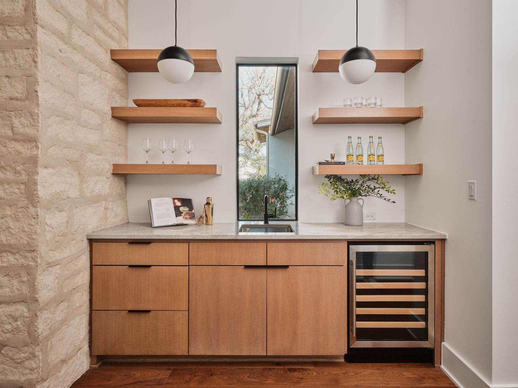 183 Tiffanie Way Austin, TX 78737 - Photo 15 of 37 Indoor wet bar with modern cabinets, open shelves, light stone counters, beverage cooler, and dark wood-style floors