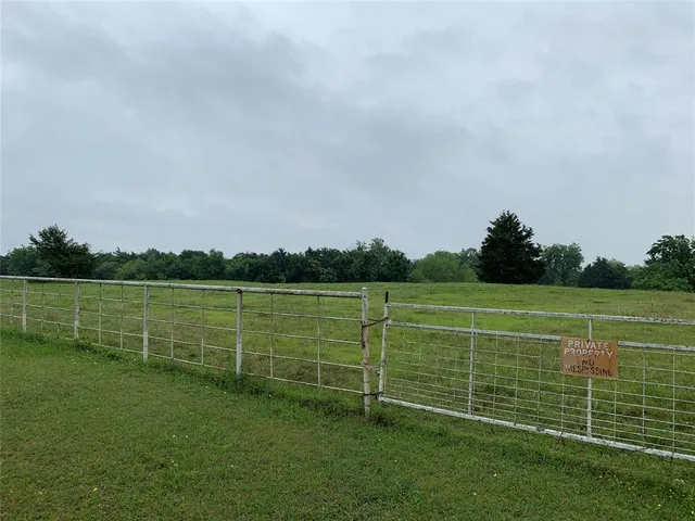 a view of a field with wooden fence