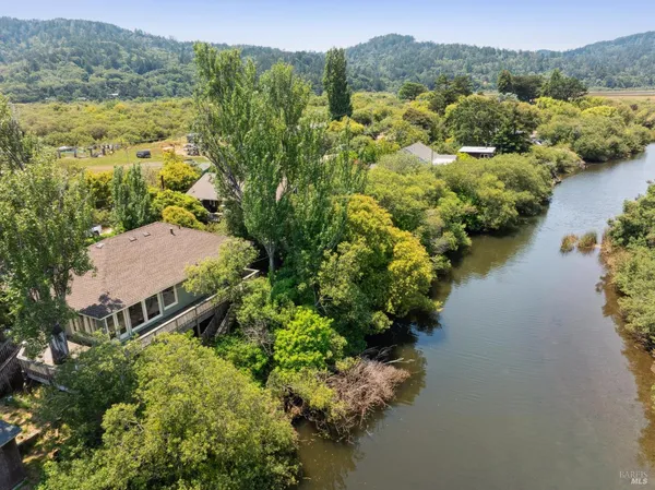 an aerial view of a house with a garden and lake view