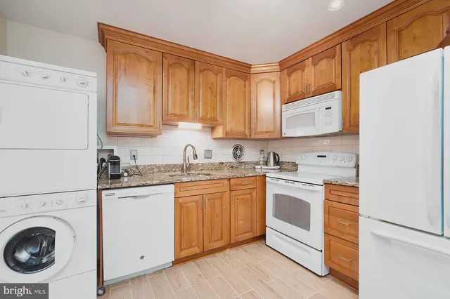 a kitchen with stainless steel appliances granite countertop a sink and a stove with white countertops