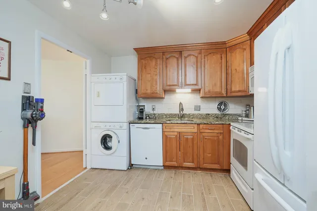a kitchen with granite countertop white cabinets and white appliances