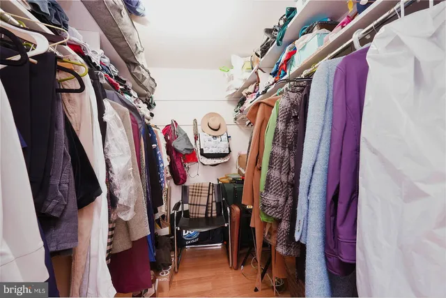 a view of walk in closet with clothes