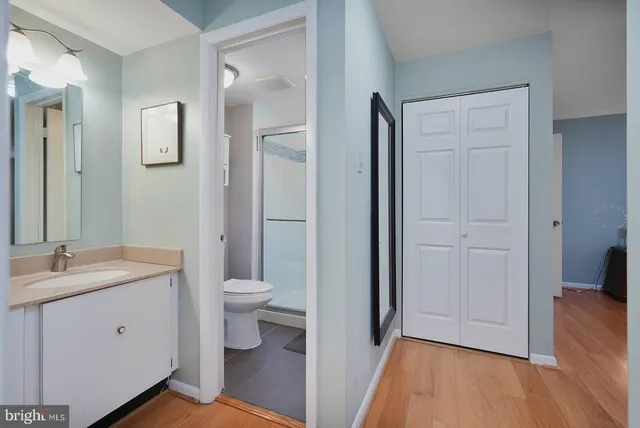 a bathroom with a granite countertop toilet a sink and a mirror