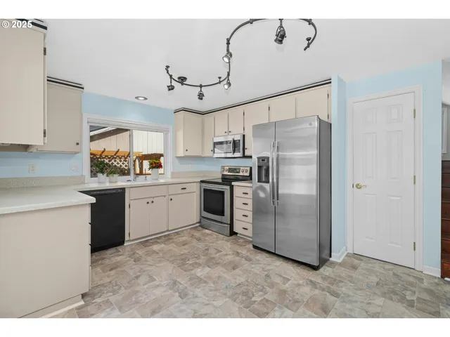 a kitchen with stainless steel appliances a refrigerator sink and cabinets