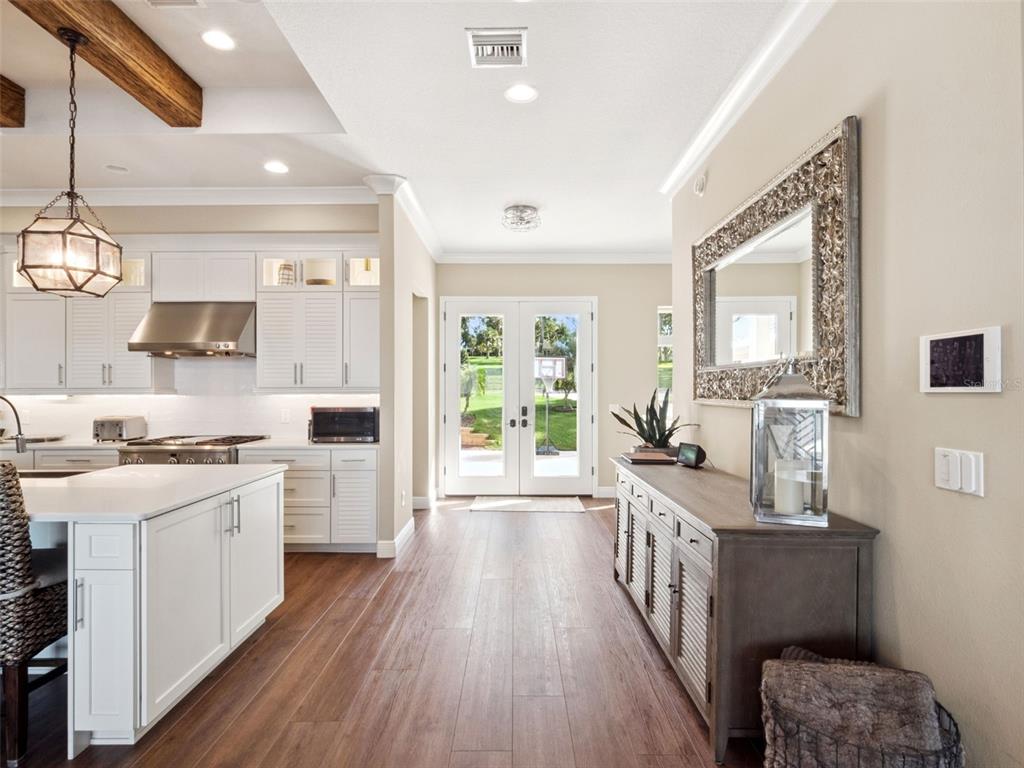 12943 Southeast Sunset Harbor Road Weirsdale, FL 32195 - Photo 17 of 65 a large kitchen with stainless steel appliances a stove a sink dishwasher a microwave oven and a dining table with wooden floor