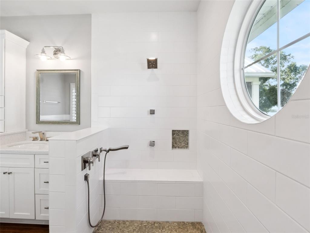 12943 Southeast Sunset Harbor Road Weirsdale, FL 32195 - Photo 28 of 65 a bathroom with a sink a mirror and a shower