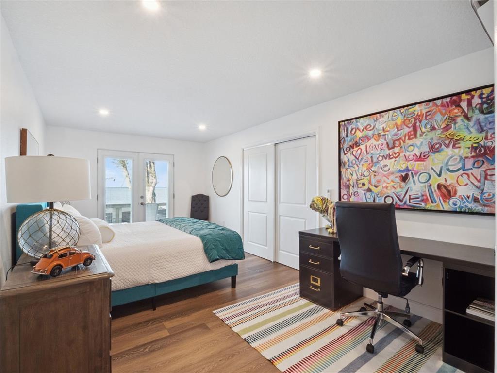 12943 Southeast Sunset Harbor Road Weirsdale, FL 32195 - Photo 30 of 65 a bedroom with a bed and wooden floor