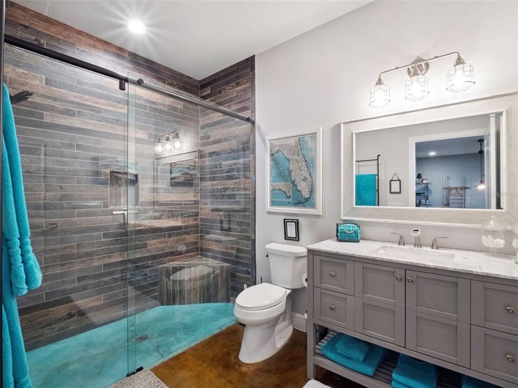 12943 Southeast Sunset Harbor Road Weirsdale, FL 32195 - Photo 32 of 65 a bathroom with a toilet sink double vanity and mirror