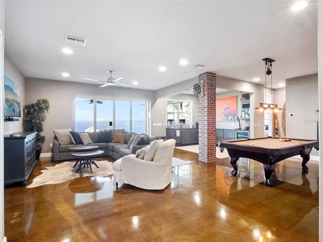 a living room with patio furniture and a floor to ceiling window