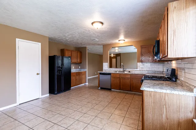 a kitchen with stainless steel appliances granite countertop a refrigerator and a sink