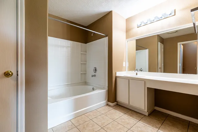 a spacious bathroom with a bathtub sink and mirror
