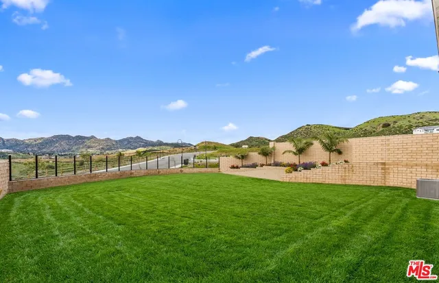 a view of a garden with a house in the background