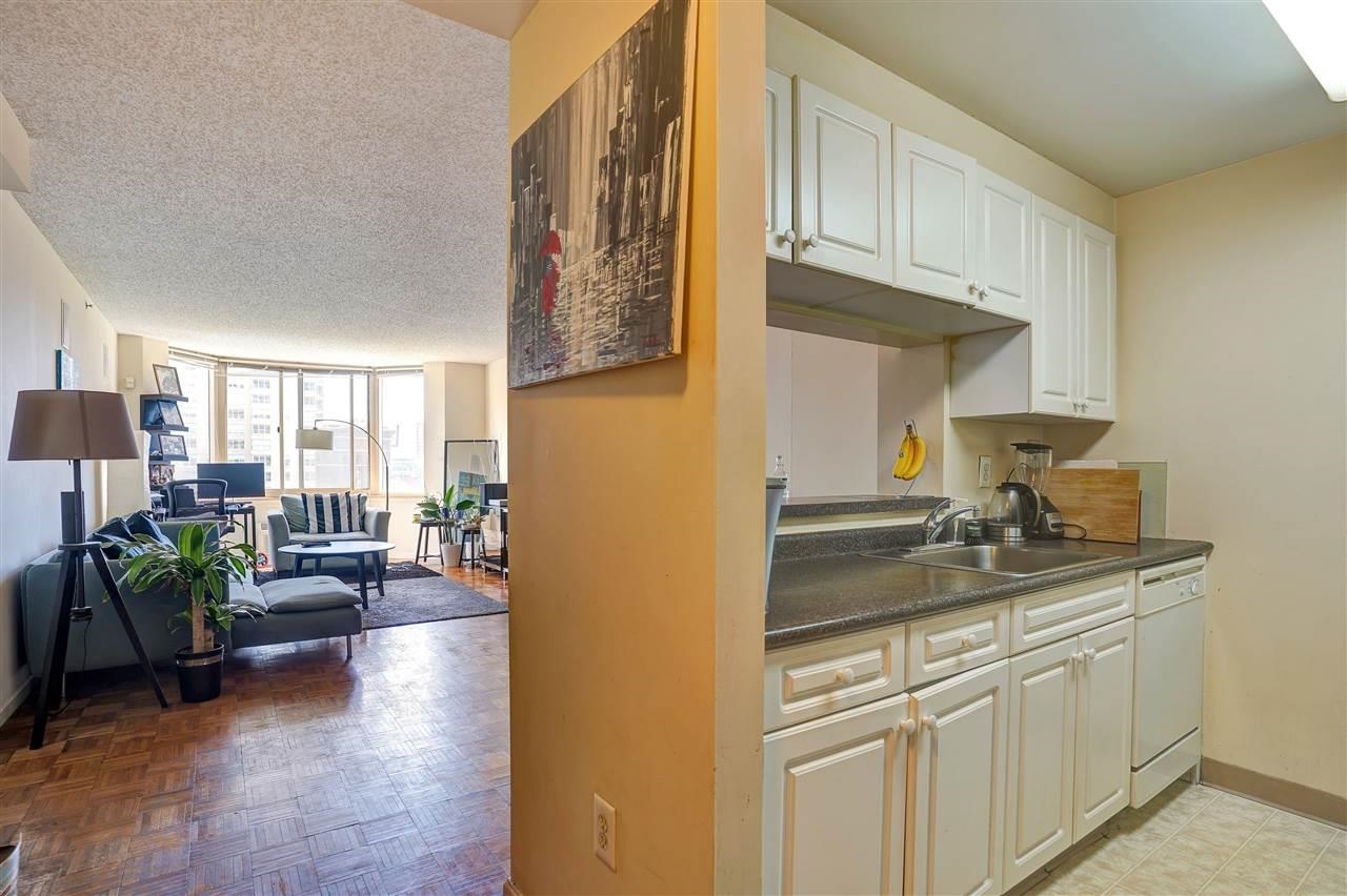 1 2nd Street, Unit 1105 Jersey City, NJ 07302 - Photo 11 of 17 a kitchen with stainless steel appliances granite countertop a sink stove and cabinets