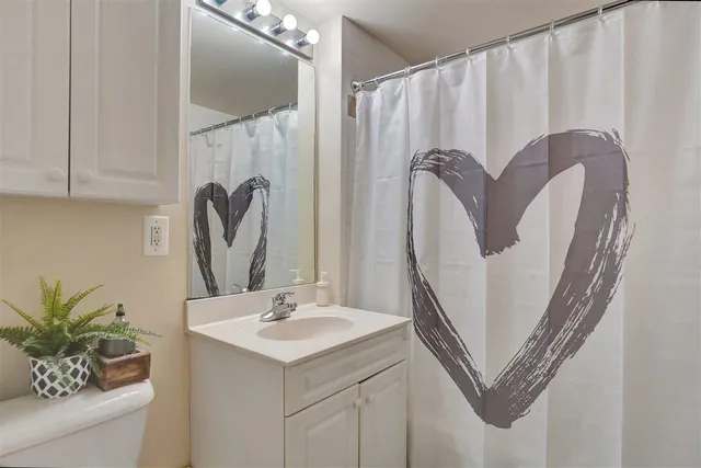 a bathroom with a sink a mirror and a shower curtain
