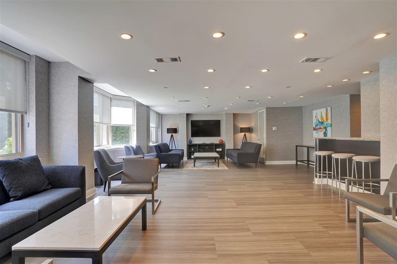 1 2nd Street, Unit 1105 Jersey City, NJ 07302 - Photo 15 of 17 a living room with furniture flat screen tv and couches