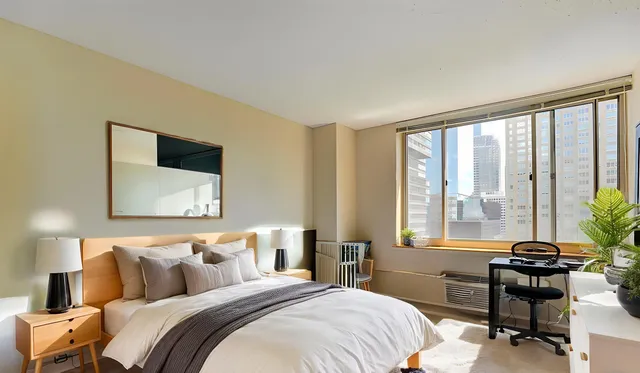 a bedroom with a bed and a large window