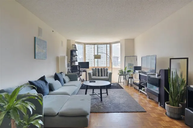 a living room with furniture a large window and a flat screen tv