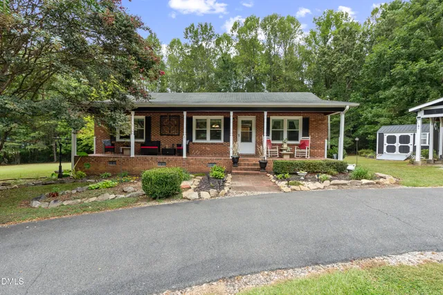 a front view of a house with a yard and potted plants