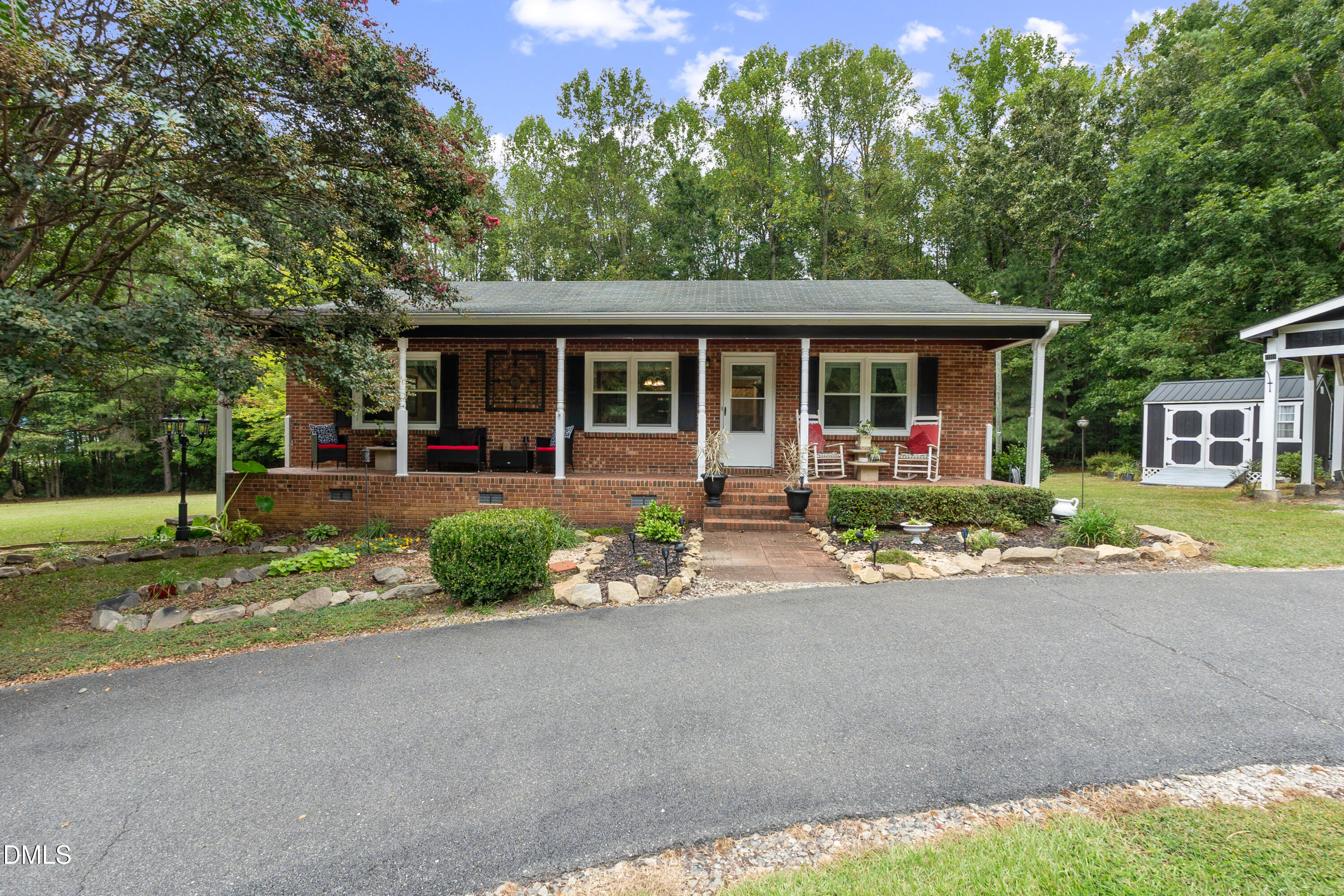 a front view of a house with a yard and potted plants