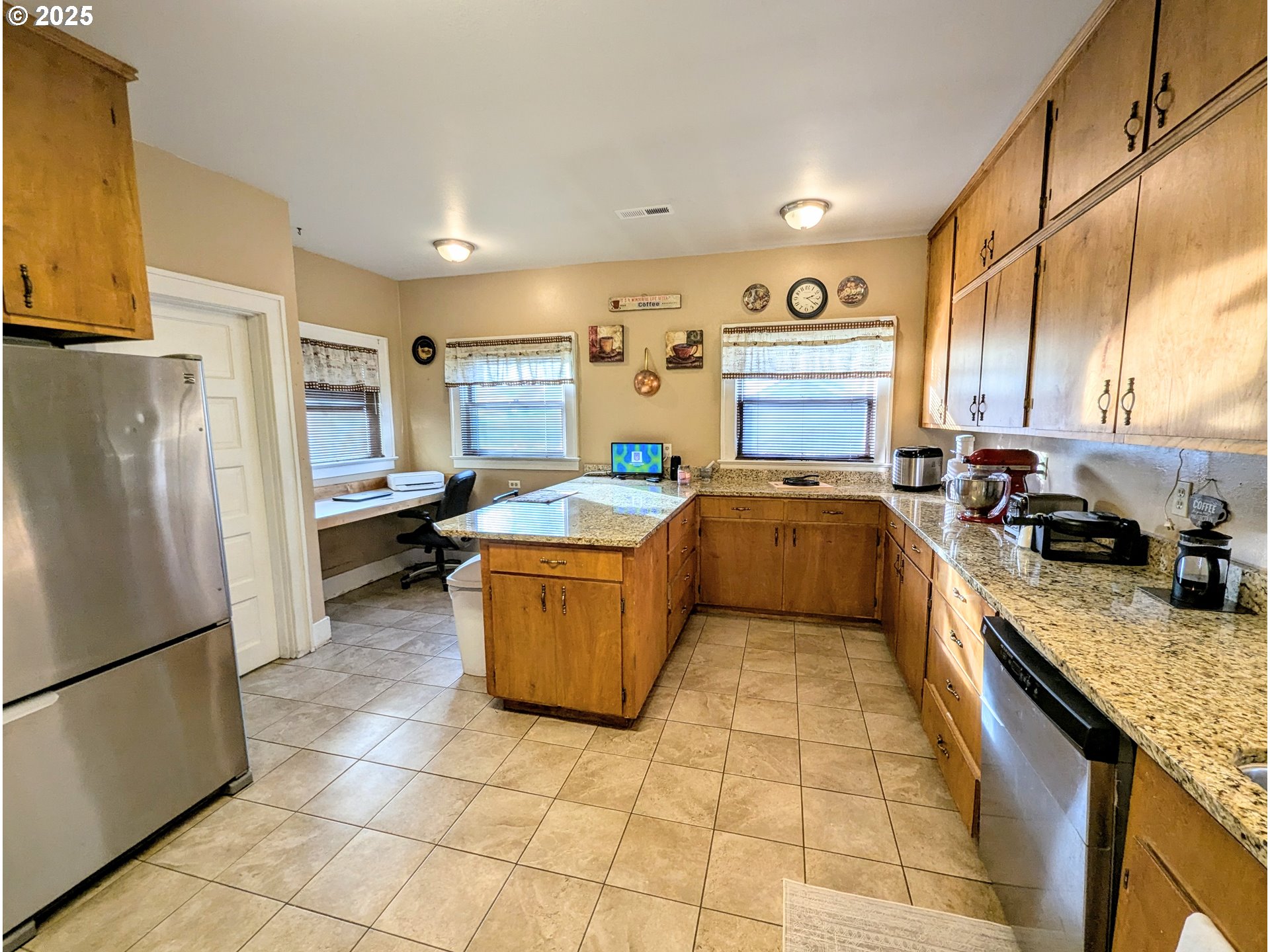 1302 9th Street La Grande, OR 97850 - Photo 10 of 15 a kitchen with stainless steel appliances granite countertop a sink refrigerator and cabinets