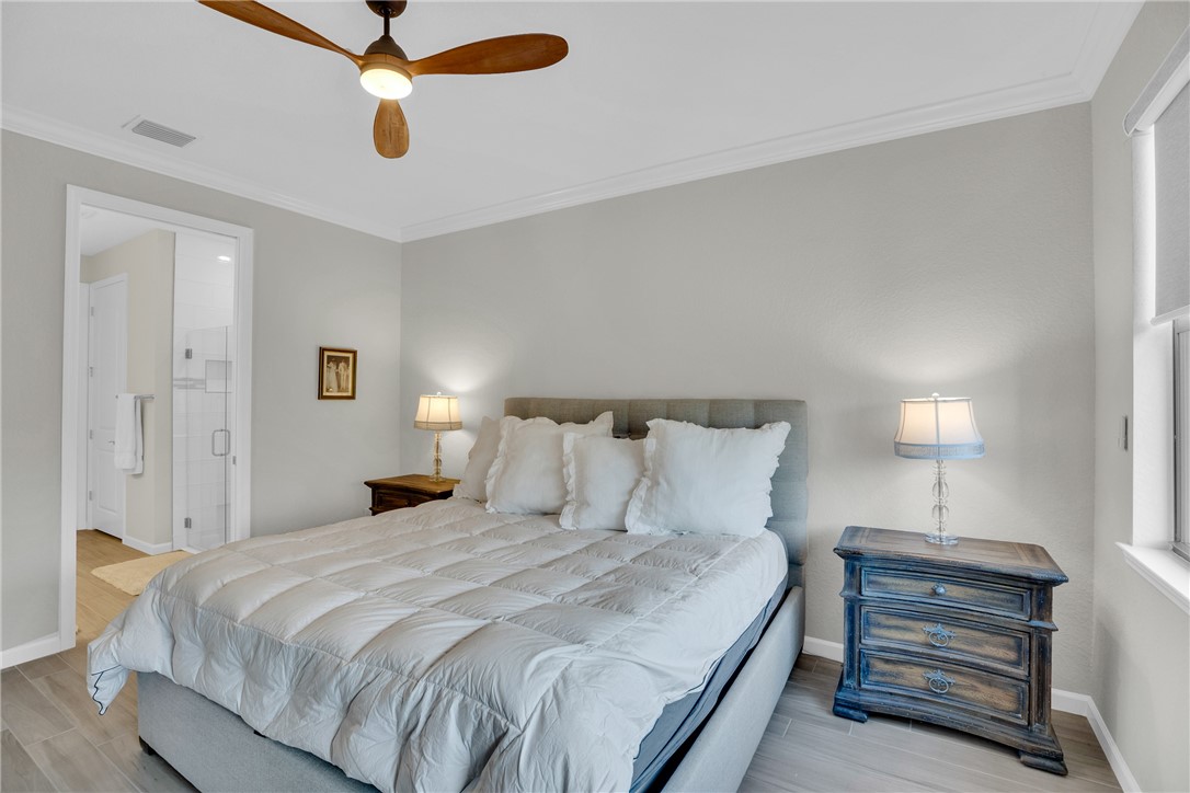 5292 Unity Square Vero Beach, FL 32967 - Photo 15 of 36 a bedroom with a bed and a chandelier