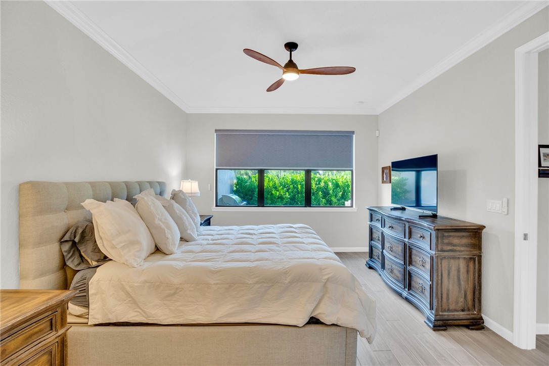 5292 Unity Square Vero Beach, FL 32967 - Photo 16 of 36 a bedroom with a bed and a flat screen tv