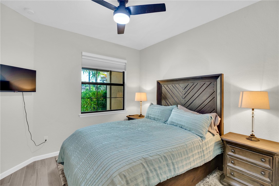 5292 Unity Square Vero Beach, FL 32967 - Photo 19 of 36 a bedroom with a bed and a flat tv screen on dresser