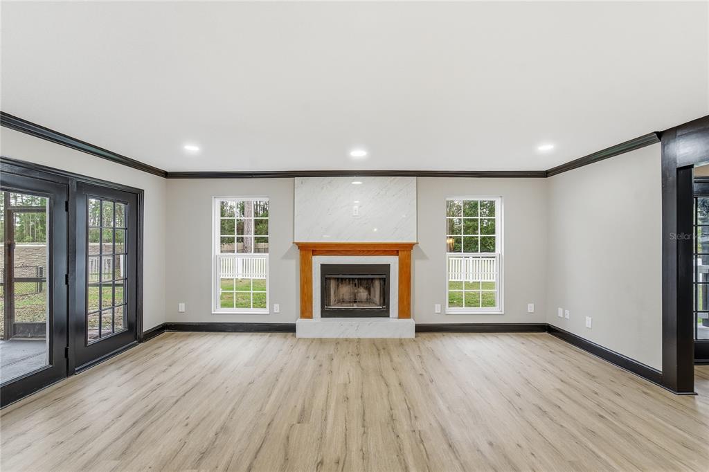 14728 Henson Road Orlando, FL 32832 - Photo 64 of 79 an empty room with wooden floor fireplace and windows