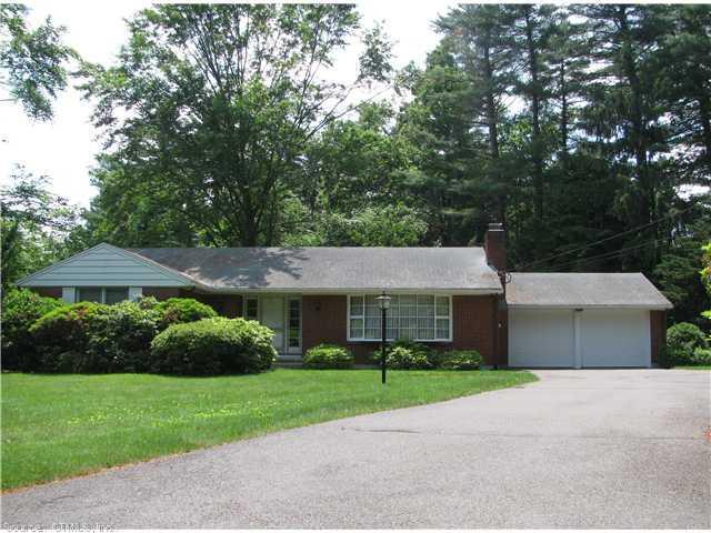 a front view of a house with a garden and plants
