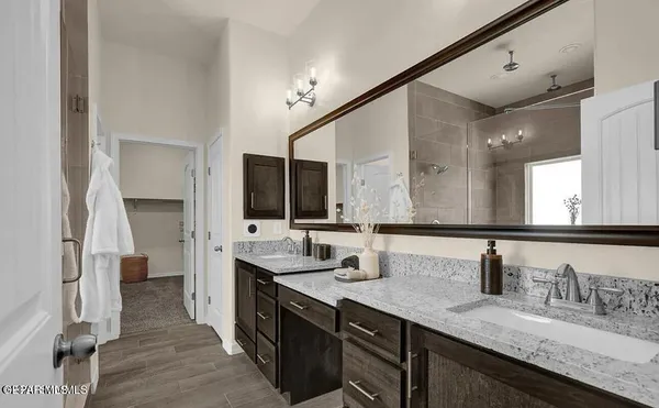 a bathroom with double vanity and a mirror