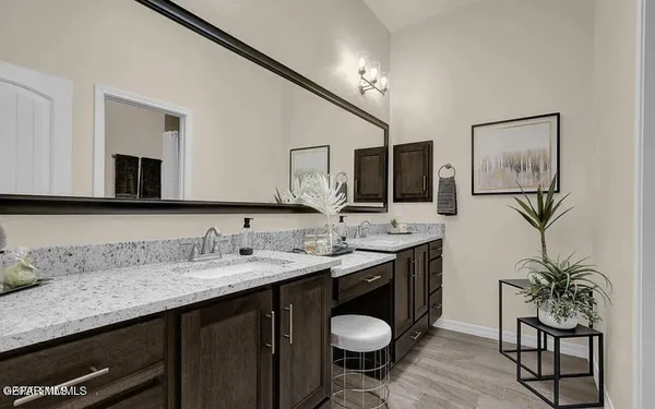 a bathroom with a granite countertop sink a mirror and a toilet
