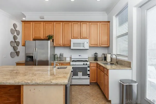 a kitchen with stainless steel appliances granite countertop a sink stove and refrigerator