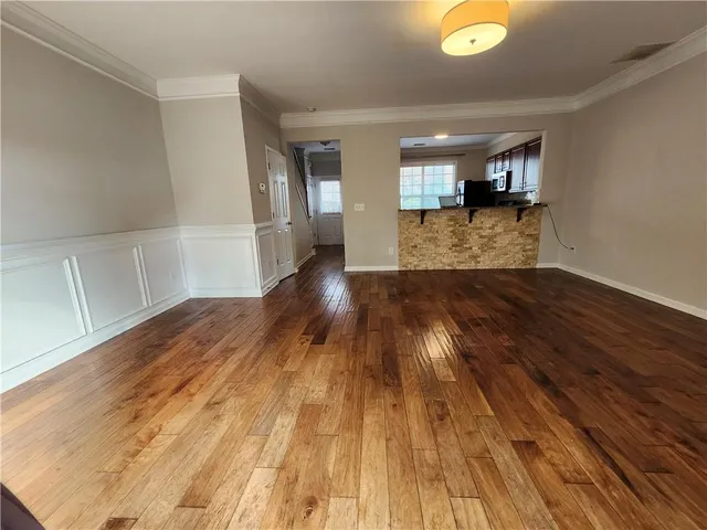 a view of a big room with wooden floor and windows