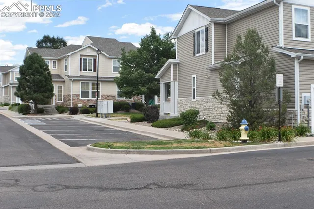 a front view of a building with a garden and plants