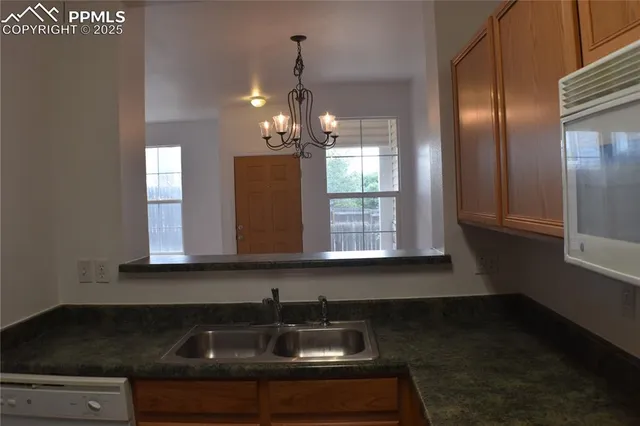 a kitchen with stainless steel appliances a sink dishwasher a refrigerator and cabinets