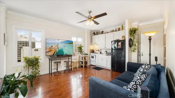 a living room with furniture kitchen view and a refrigerator