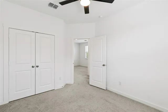an empty room with chandelier fan