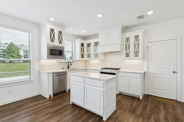 a kitchen with granite countertop white cabinets and white appliances