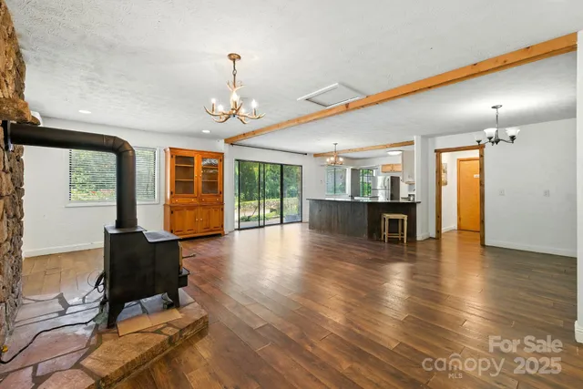 a view of a kitchen with kitchen island stainless steel appliances a sink and living room view
