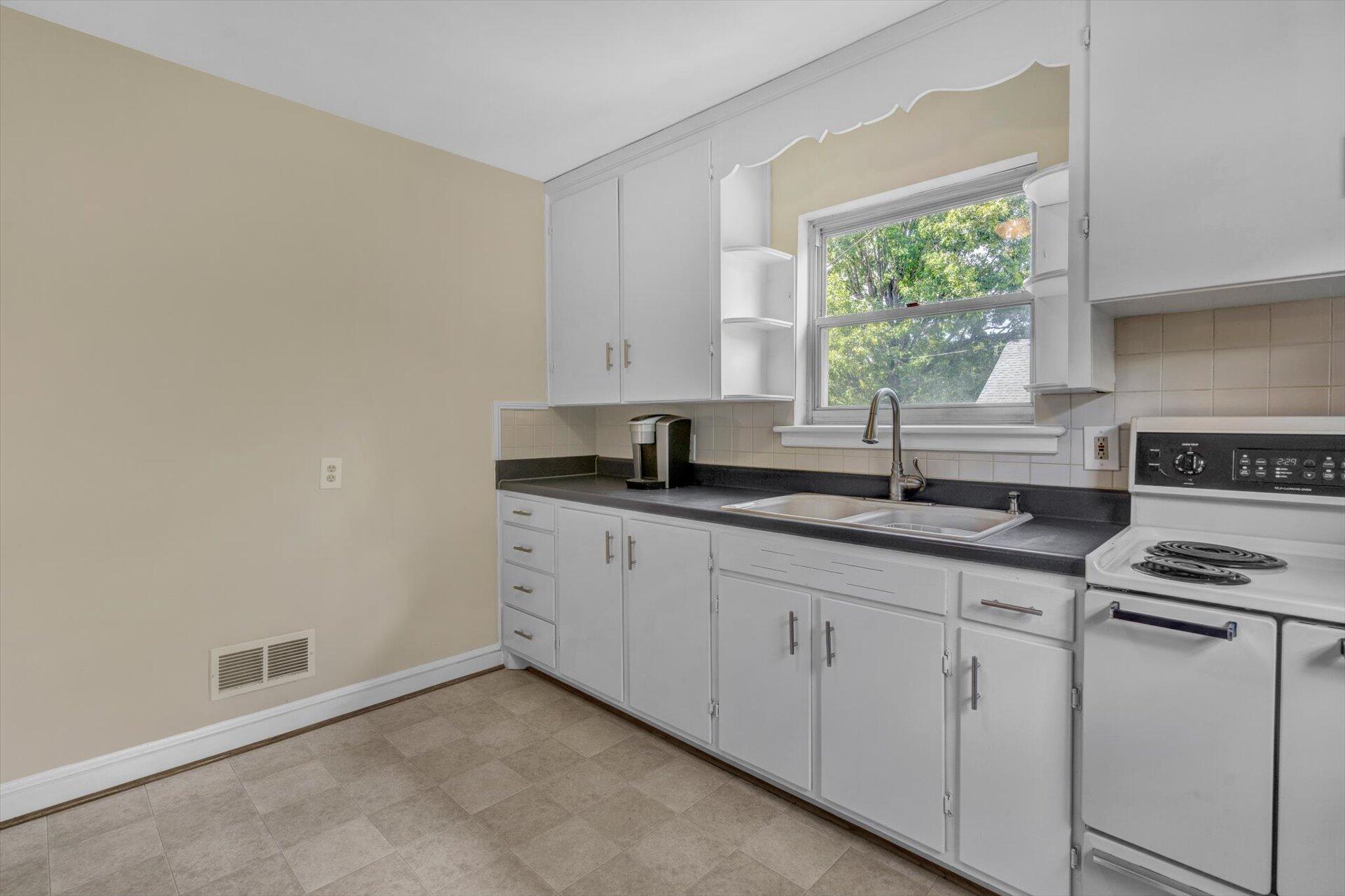 4546 Cowman Road Roanoke, VA 24014 - Photo 12 of 29 a kitchen with granite countertop white cabinets and a stove
