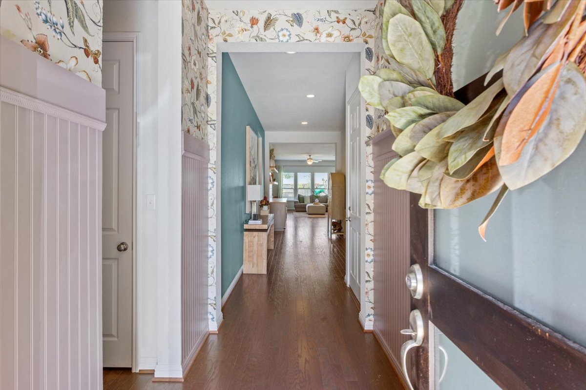 424 Millard Street Georgetown, TX 78628 - Photo 7 of 37 A welcoming entryway with richly stained hardwood flooring and stylish accent walls.