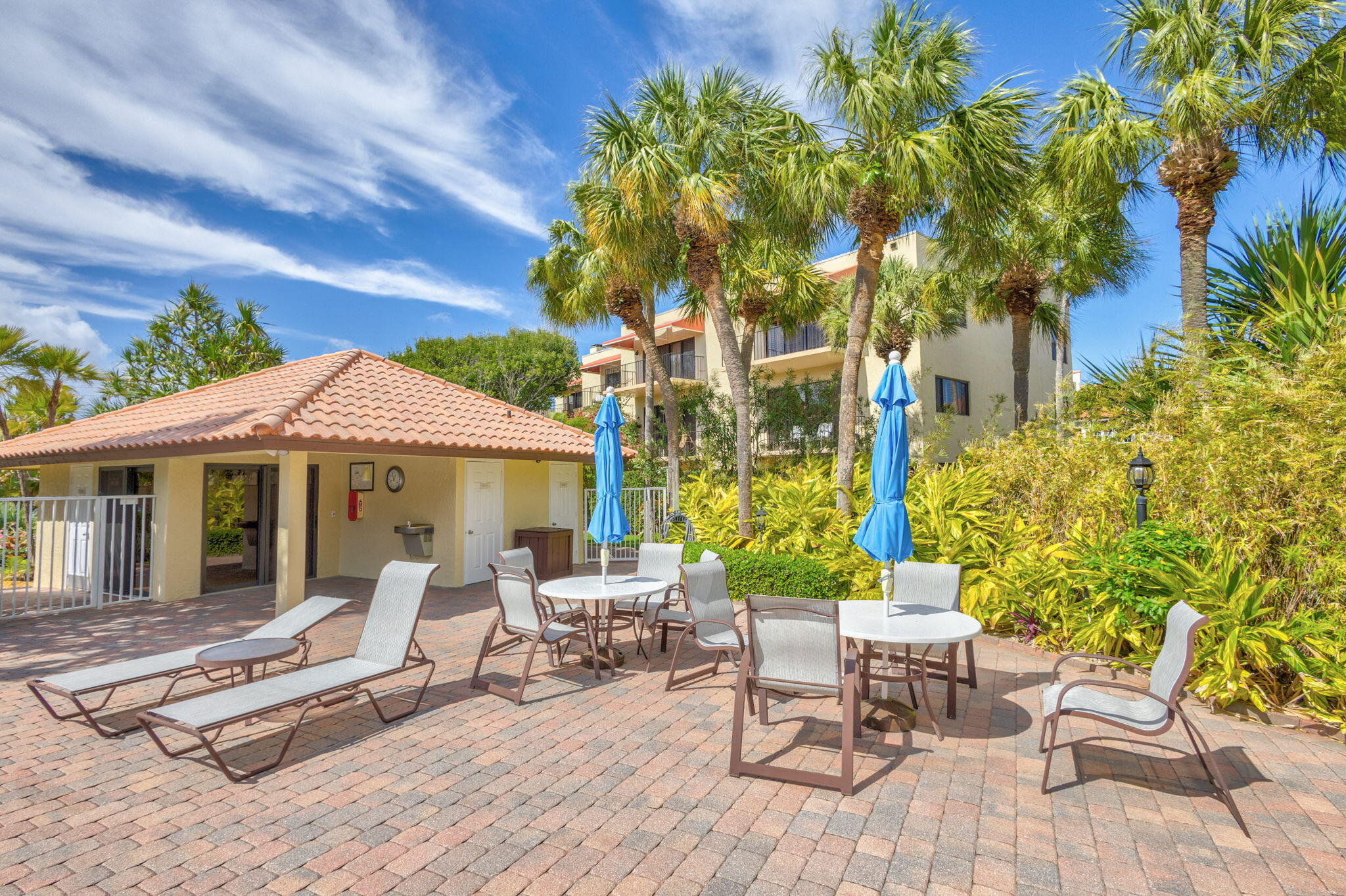 170 Celestial Way, Unit 83 Juno Beach, FL 33408 - Photo 61 of 70 a view of a patio with a table and chairs under an umbrella